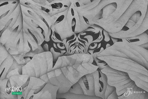 tiger’s head emerging from behind the leaves in shades of gray - wall mural